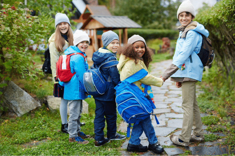 Groupe d’enfants souriants avec sacs à dos